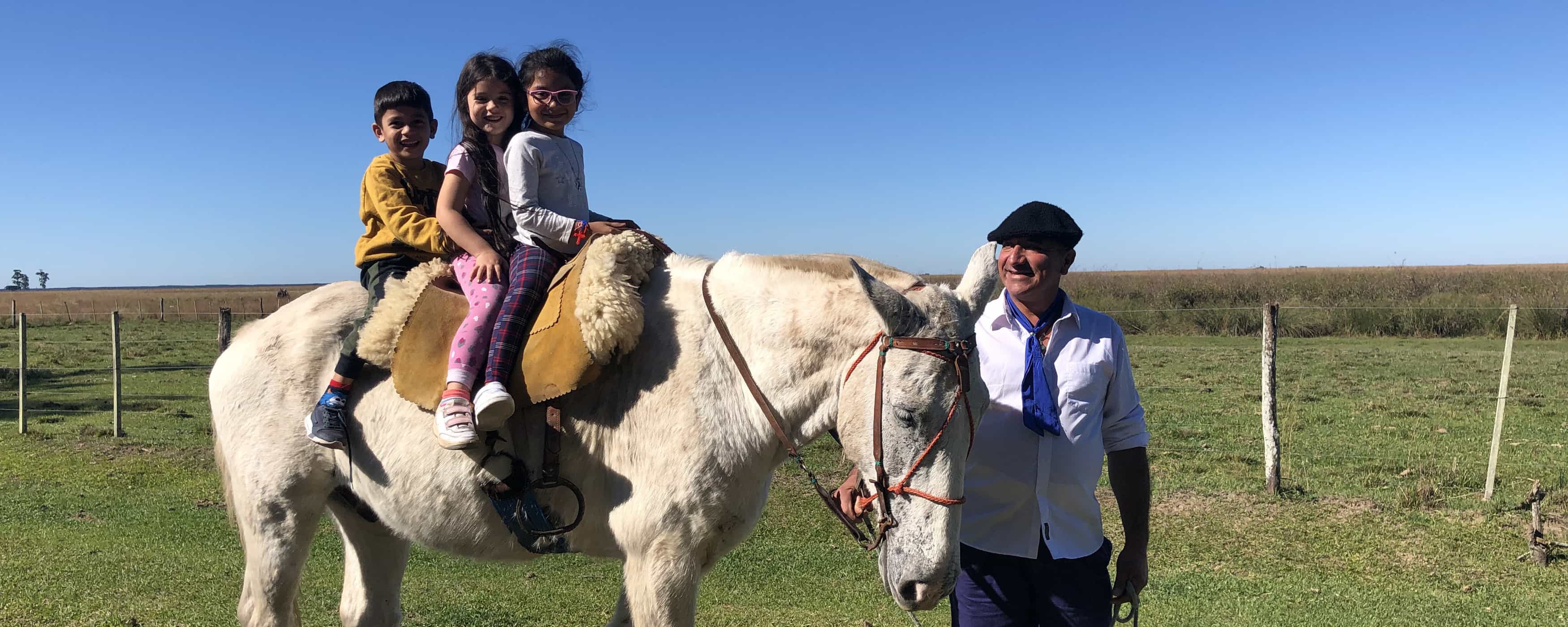 foto de tres niños en un pony